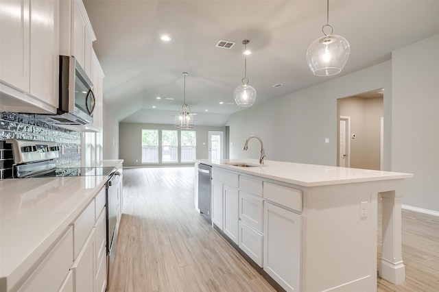 kitchen with white cabinetry, sink, an island with sink, and stainless steel appliances