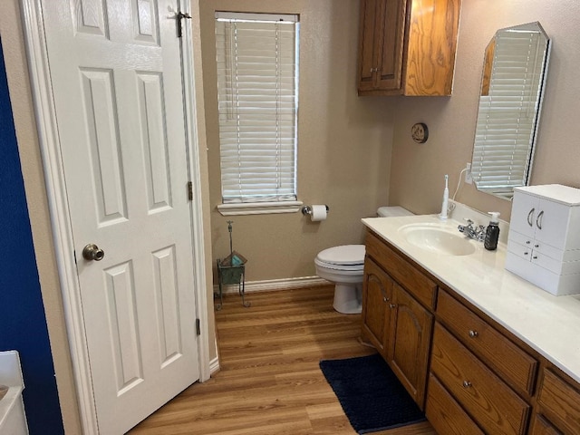 bathroom with wood-type flooring, vanity, and toilet