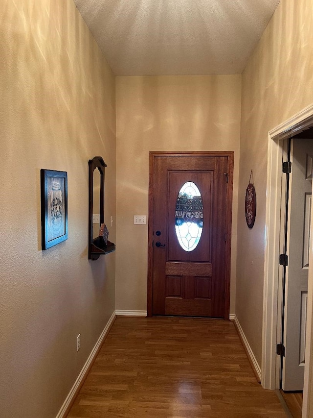 doorway featuring a textured ceiling and hardwood / wood-style flooring