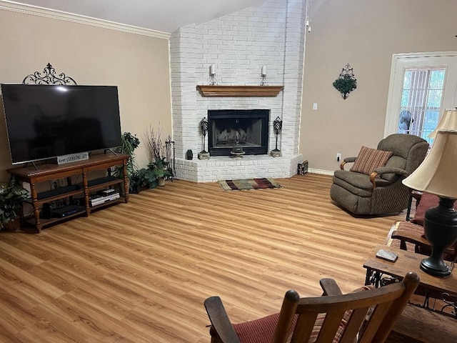 living room featuring crown molding, hardwood / wood-style floors, vaulted ceiling, and a brick fireplace