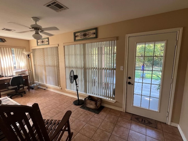 doorway with ceiling fan and light tile patterned flooring