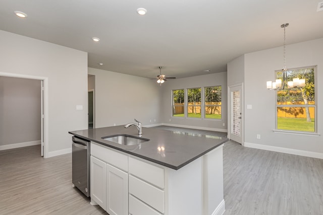 kitchen featuring white cabinetry, sink, pendant lighting, light hardwood / wood-style floors, and a center island with sink