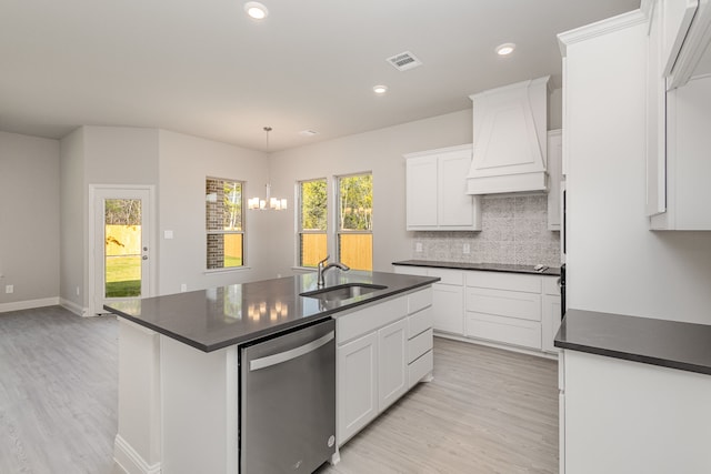 kitchen with white cabinets, pendant lighting, a center island with sink, and sink