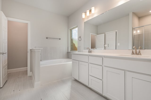 bathroom featuring plus walk in shower, vanity, and tile patterned floors