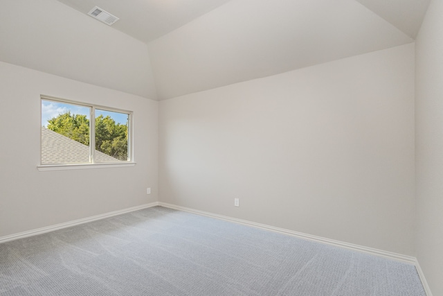 spare room featuring carpet floors and vaulted ceiling