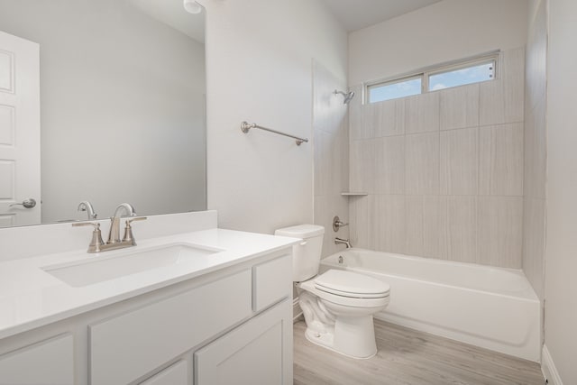 full bathroom featuring vanity, toilet, wood-type flooring, and tiled shower / bath combo