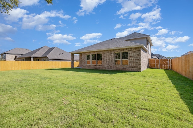 rear view of house featuring a lawn