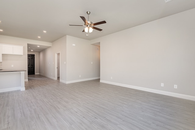 unfurnished living room featuring ceiling fan and light hardwood / wood-style flooring