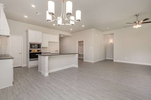 kitchen with light wood-type flooring, backsplash, stainless steel appliances, sink, and white cabinets