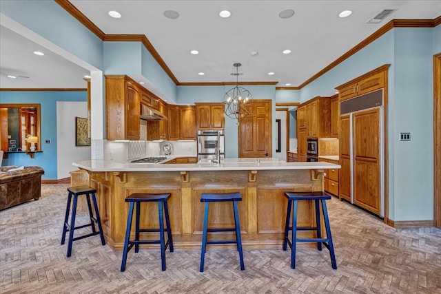 kitchen featuring a kitchen breakfast bar, kitchen peninsula, light parquet floors, appliances with stainless steel finishes, and ornamental molding