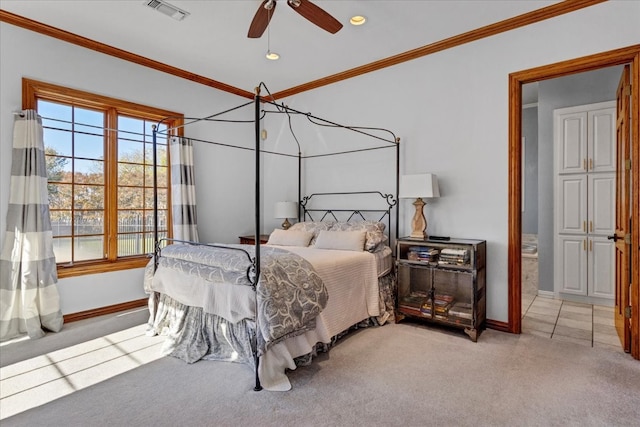 carpeted bedroom featuring ceiling fan, ornamental molding, and ensuite bathroom