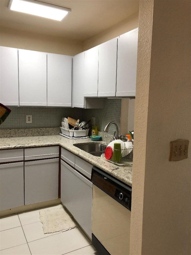 kitchen featuring decorative backsplash, dishwasher, white cabinets, and sink