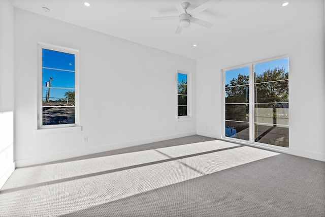 carpeted empty room featuring a wealth of natural light and ceiling fan