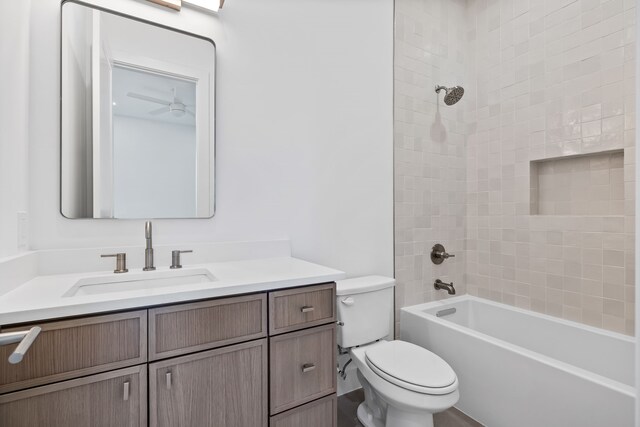 full bathroom featuring tiled shower / bath, vanity, and toilet