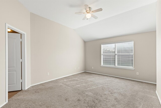 carpeted living room with ceiling fan and vaulted ceiling