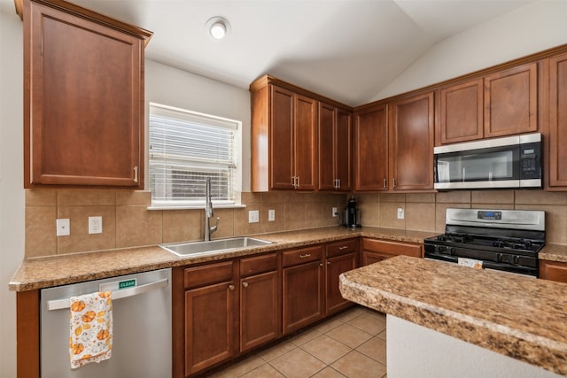 kitchen featuring sink, stainless steel appliances, tasteful backsplash, vaulted ceiling, and light tile patterned flooring