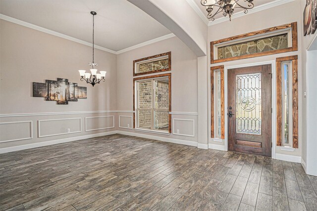 foyer entrance with a chandelier, dark hardwood / wood-style floors, and crown molding