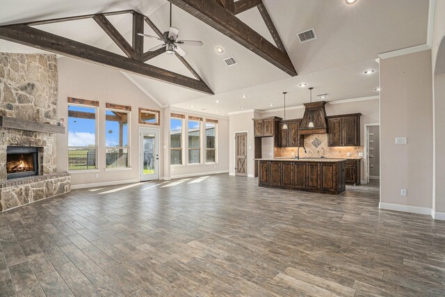 living room featuring high vaulted ceiling, a stone fireplace, dark hardwood / wood-style floors, ceiling fan, and beam ceiling