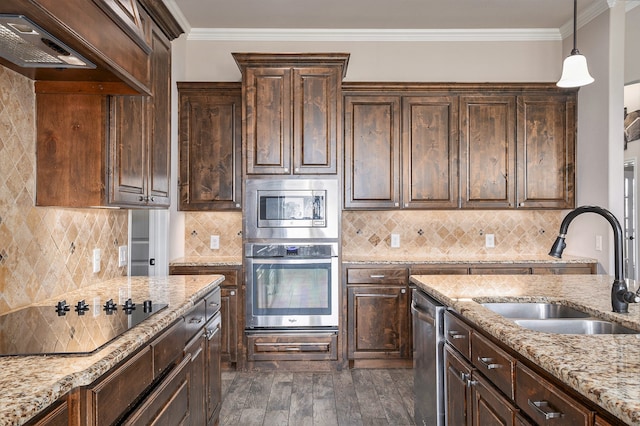 kitchen with light stone countertops, dark brown cabinetry, stainless steel appliances, and sink