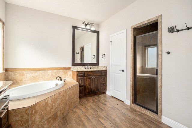 bathroom featuring vanity, wood-type flooring, and shower with separate bathtub