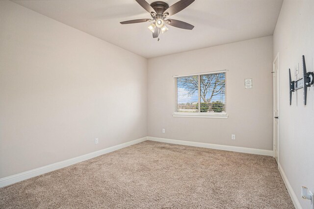 carpeted spare room featuring ceiling fan