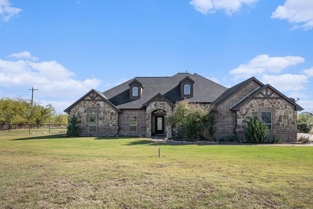 french country inspired facade with a front yard