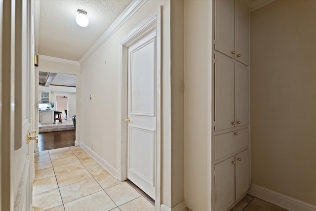 hall with crown molding, light tile patterned floors, and a textured ceiling