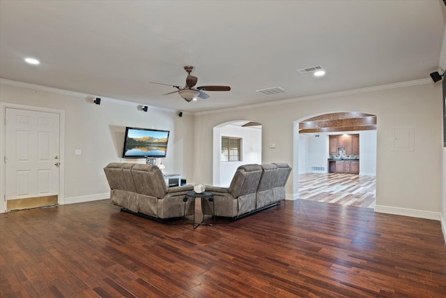 living room featuring ceiling fan, crown molding, and dark wood-type flooring