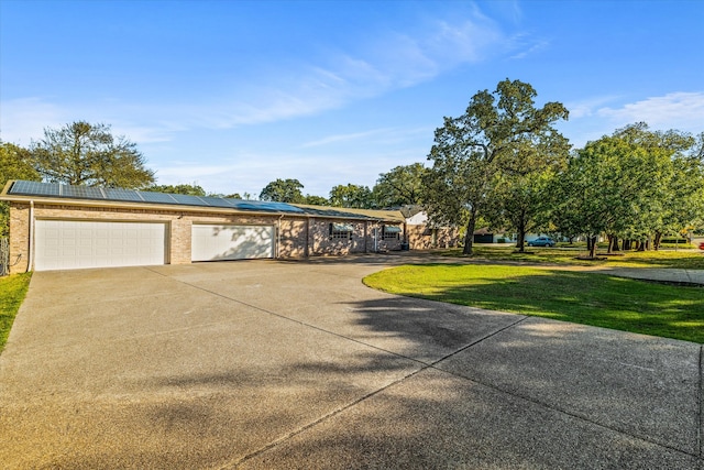 view of front facade featuring a front lawn and solar panels