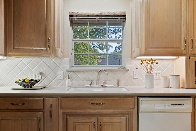 kitchen featuring white dishwasher, tasteful backsplash, and sink