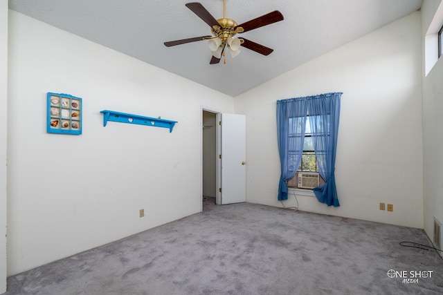 carpeted spare room with ceiling fan, cooling unit, and vaulted ceiling