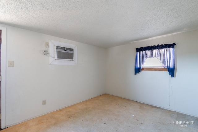 carpeted spare room featuring a wall mounted air conditioner and a textured ceiling