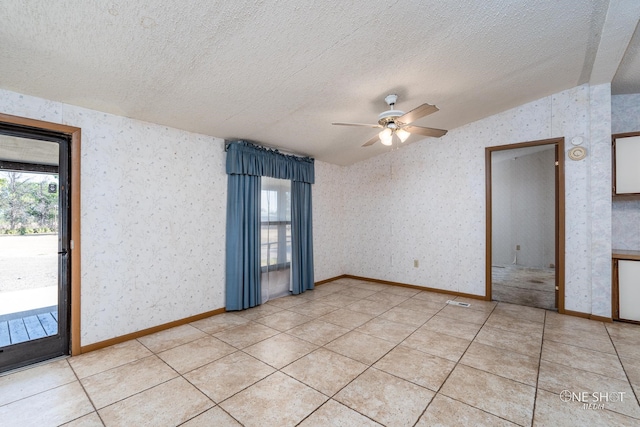 tiled spare room with a textured ceiling, vaulted ceiling, and ceiling fan