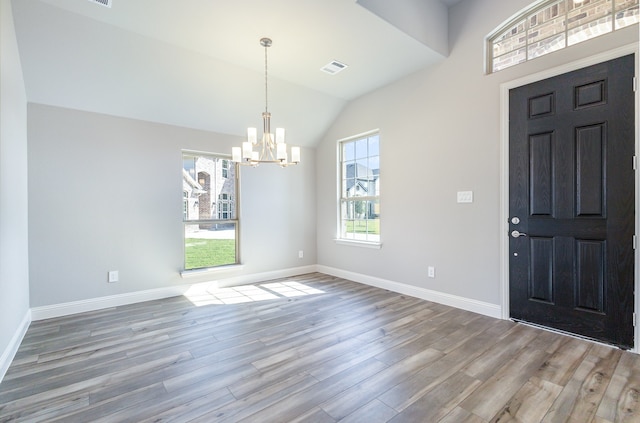 foyer featuring a notable chandelier, vaulted ceiling, and hardwood / wood-style flooring