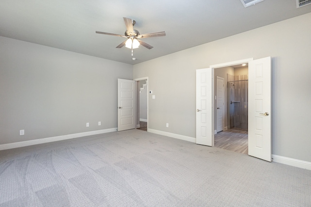 unfurnished bedroom featuring light colored carpet and ceiling fan