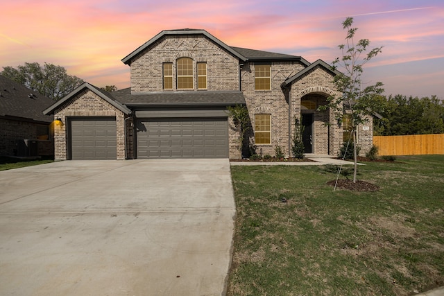 french country inspired facade featuring a garage and a yard