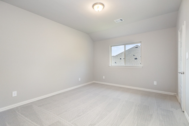 carpeted spare room featuring lofted ceiling