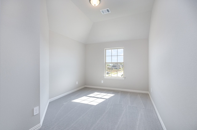 unfurnished room featuring carpet floors and lofted ceiling