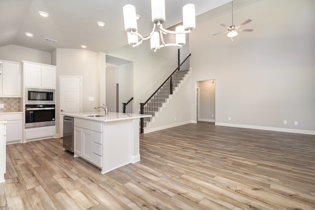 kitchen featuring white cabinetry, an island with sink, light wood-type flooring, and appliances with stainless steel finishes