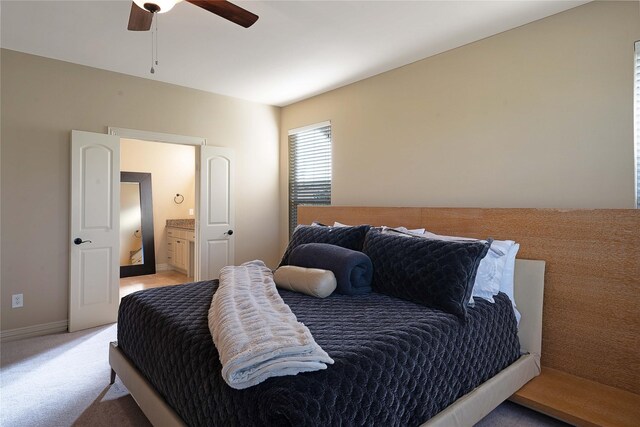 bedroom with connected bathroom, ceiling fan, and light colored carpet