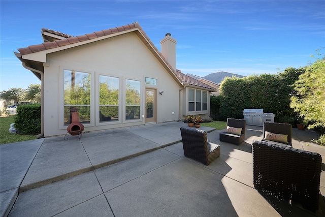 back of house with outdoor lounge area and a patio