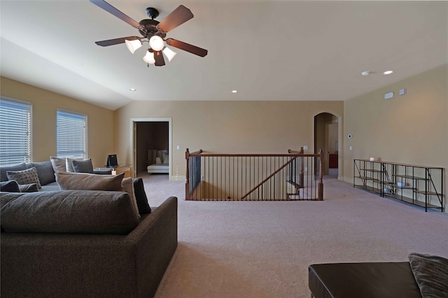 carpeted living room with ceiling fan and lofted ceiling