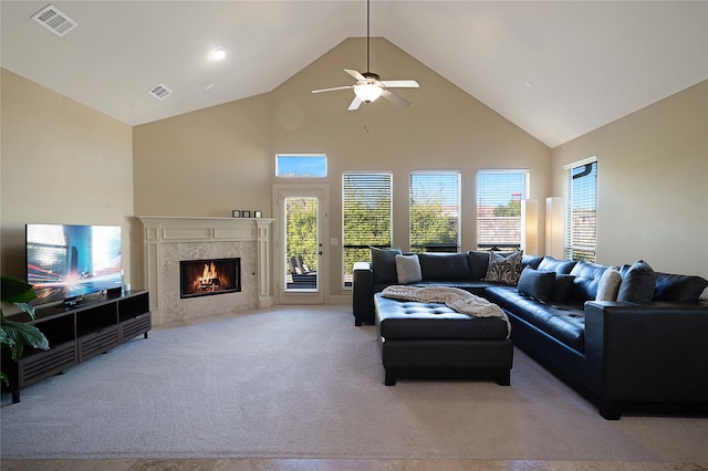 living room with a fireplace, light colored carpet, high vaulted ceiling, and ceiling fan