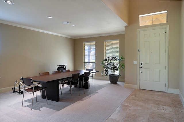 dining area featuring light colored carpet and crown molding