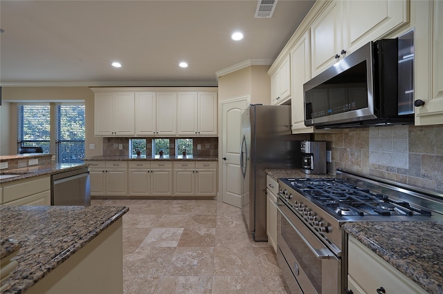 kitchen featuring tasteful backsplash, crown molding, white cabinets, and appliances with stainless steel finishes