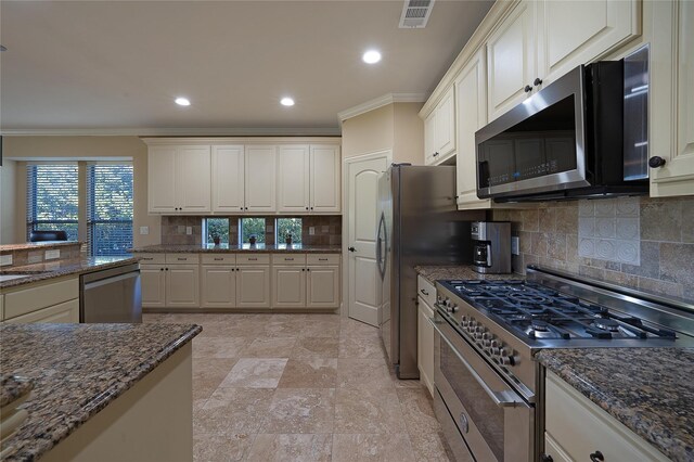 kitchen featuring tasteful backsplash, crown molding, white cabinets, and appliances with stainless steel finishes