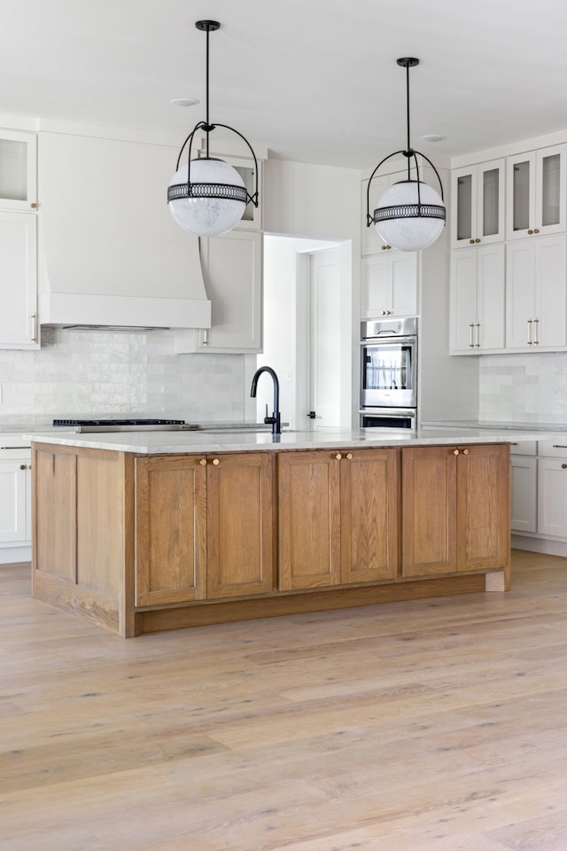 kitchen with a spacious island, glass insert cabinets, and white cabinets