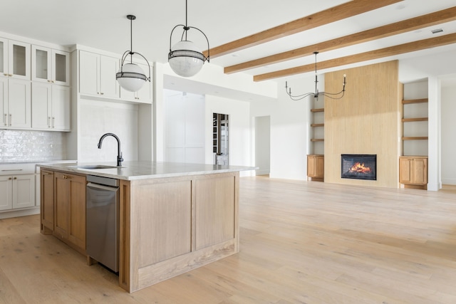 kitchen featuring light countertops, pendant lighting, white cabinetry, and a center island with sink