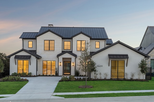 modern farmhouse with metal roof, a yard, a standing seam roof, and driveway