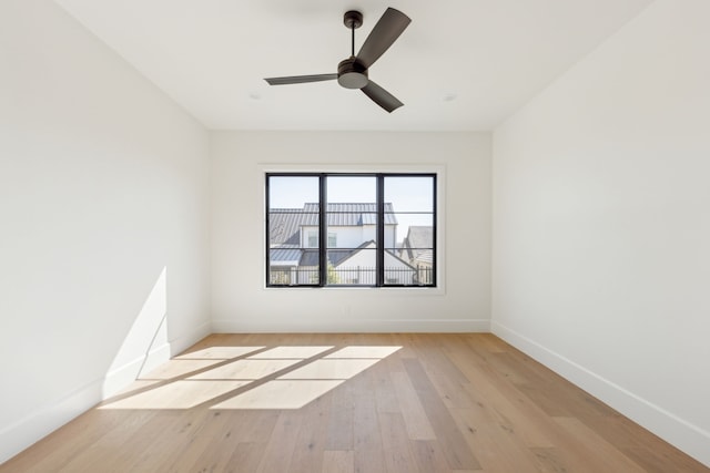 unfurnished room with a ceiling fan, baseboards, and light wood finished floors